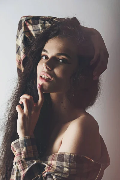 Retrato emocional del estudio de una mujer joven con auriculares inalámbricos y camisa a cuadros — Foto de Stock