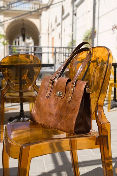 Close-up photo of yellow leather bag on a stylish plastic chair — Stock Photo, Image