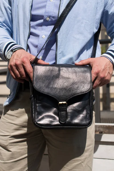 Close-up photo of black leather bag in mans hand — Stock Photo, Image