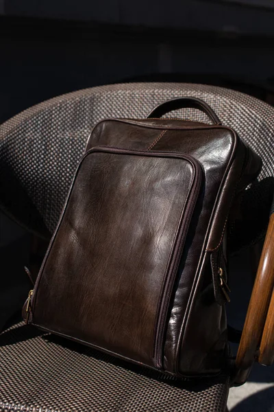 Brown leather backpack on the stylish chair