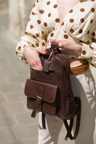 Part photo of a woman with a brown leather backpack with antique and retro look. Outdoors photo — Stok fotoğraf