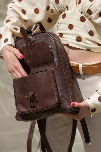 Part photo of a woman with a brown leather backpack with antique and retro look. Outdoors photo — Stock Photo, Image