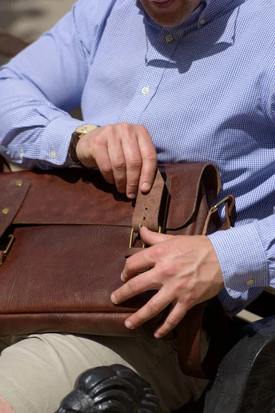 Part photo of a man with a brown leather briefcase with antique and retro look. Outdoors photo — Stok fotoğraf