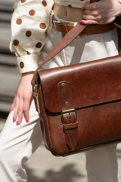 Part photo of a woman with a brown leather briefcase with antique and retro look. Outdoors photo — Stock Photo, Image