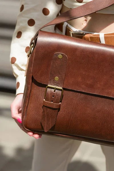 Part photo of a woman with a brown leather briefcase with antique and retro look. Outdoors photo — Stock Photo, Image