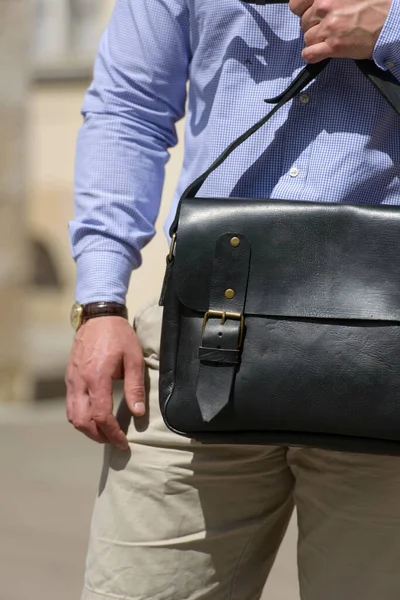 Part photo of a man with a black leather briefcase with antique and retro look. Outdoors photo — Stok fotoğraf