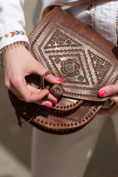 Liten brun kvinnors läder väska med ett snidat mönster. selektivt fokus — Stockfoto