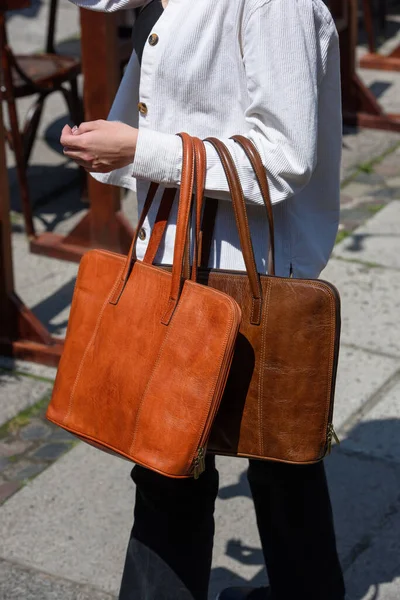 orange and brown leather bag. outdoors photo. Girl in a white jacket