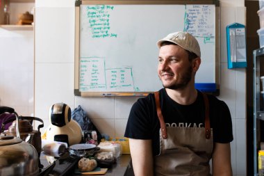 Fırıncı işinde kep ve önlüklü genç bir adam.