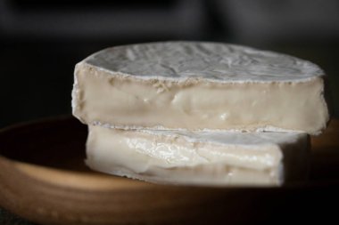 Koyu ahşap arka planda beyaz küflü ev yapımı peynir.