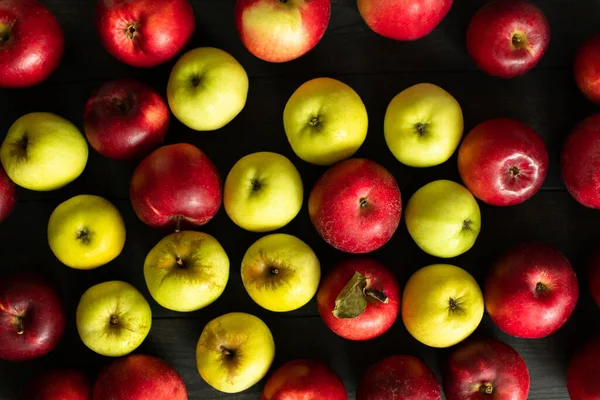 Karanlık bir arka planda kusurlu kırmızı ve yeşil elmalar. Toplu.
