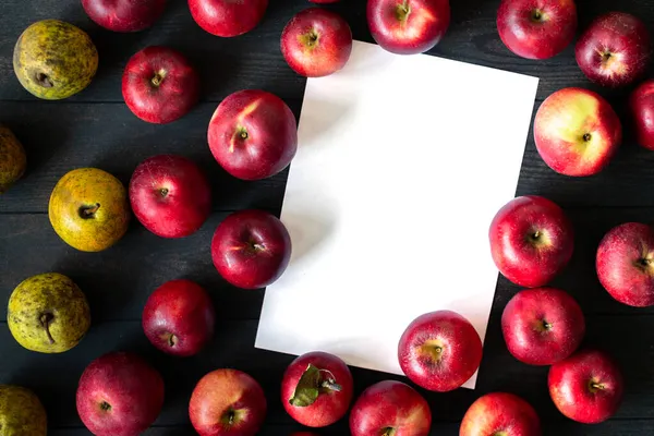 Imperfect red apples and yellow pears on a dark background. Bulk. Isolated. — Stock Photo, Image