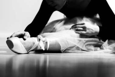 Gösteriden önce sivri uçlu bir balerin ısınıyor. Siyah beyaz fotoğraf.