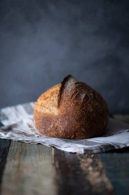 Ev yapımı buğday ekmeği. Koyu bir arka plan ve ahşap bir masa..