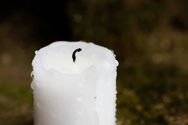 Una candela spenta dopo la pioggia. Stoppino nero e gocce d'acqua sulla cera. — Foto Stock