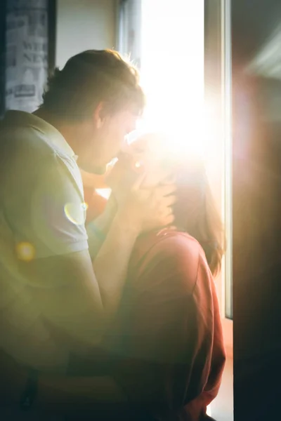 Portret pary całującej się na tle zachodzącego słońca oświetlającego kamerę. — Zdjęcie stockowe