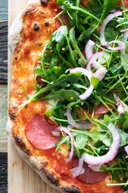 Sosisli ev yapımı pizza ve soğanlı roka..