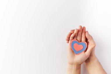 Sevgililer Günü, kağıttan yapılmış kalpler birbirine aşık bir çiftin elinde tutulur. Uzayı kopyala Metin için yer.