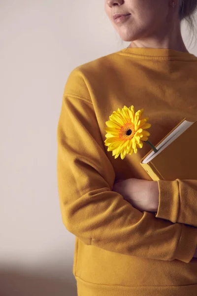 Sarı bir kitap. Elinde çiçek olan bir kadın.. — Stok fotoğraf