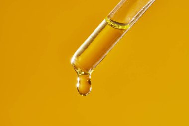 Pipetten bir damla kozmetik aromatik yağ damlıyor..