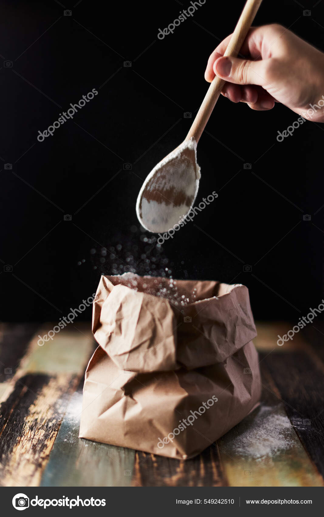 Wheat flour in a craft package. Freeze movement, spoon dark background