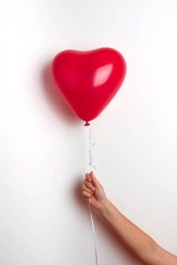 Sevgililer Günü için kalp şeklinde şişirilebilir helyum balonu elinde bir kız tarafından tutulur..