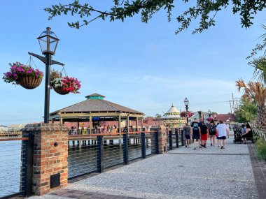 Myrtle Beach, SC / USA - 1 Eylül 2021: Asılı bitki ve yürüyen ziyaretçilerle yol kenarı manzarası