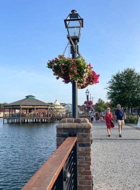 Myrtle Beach, SC / USA - 1 Eylül 2021: Asılı bitki ve yürüyen ziyaretçilerle yol kenarı manzarası