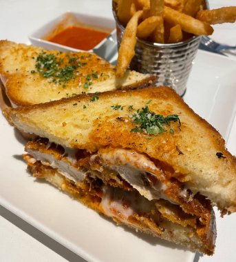 Tavuklu sandviçe yakından bakın. Kızarmış tavuk göğsü ve üstüne maydanoz ve İtalyan peyniri.