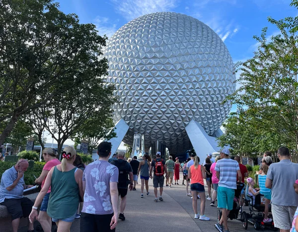 Körfez Gölü, FL USA - 15 Eylül 2022: Epcot parkının ana girişinde dünya uzay gemisiyle yürüyen turistlerin yol kenarı görüntüsü