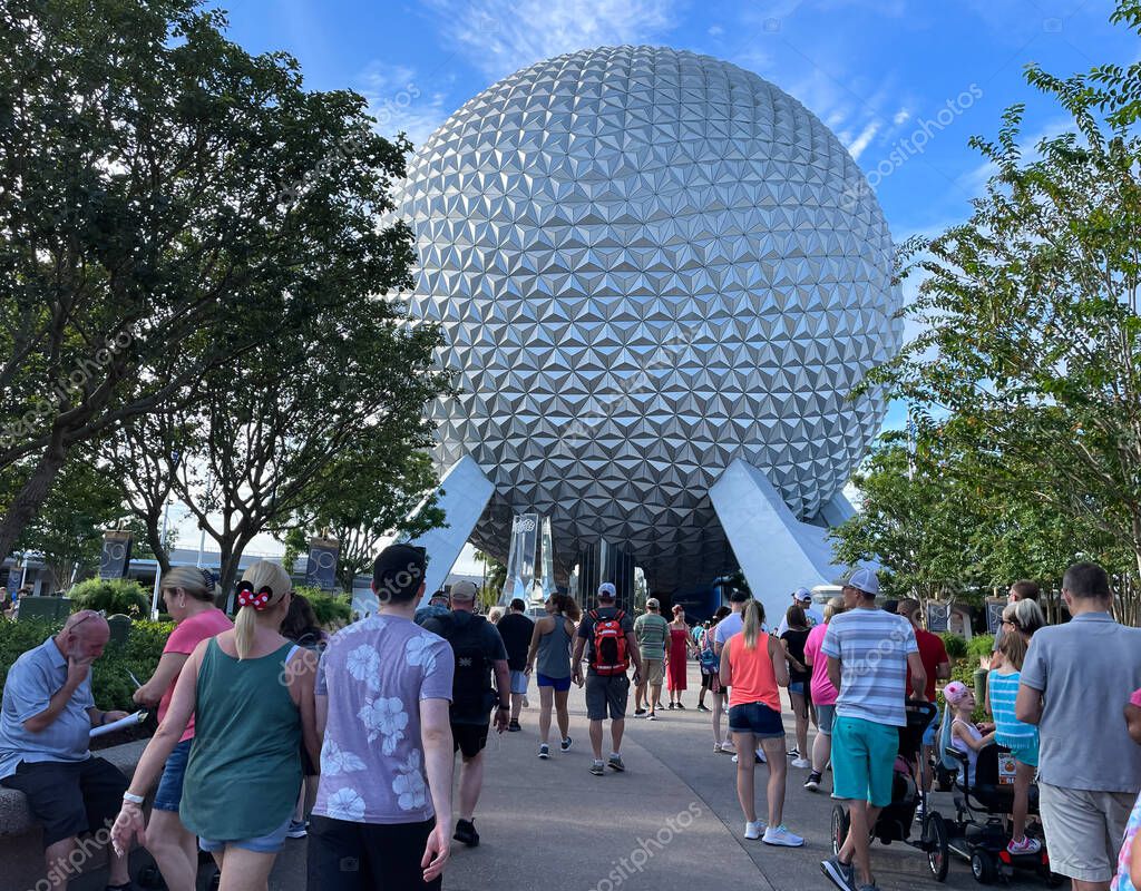 Bay lake, FL USA - September 15, 2022: Roadside view of tourists walking down the main entrance of the epcot park with spaceship earth