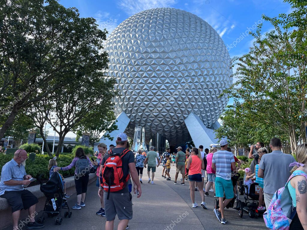 Bay lake, FL USA - September 15, 2022: Roadside view of tourists walking down the main entrance of the epcot park with spaceship earth