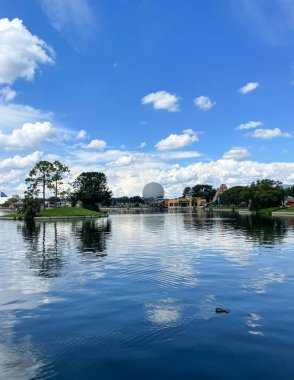 Körfez Gölü, FL USA - 15 Eylül 2022: Mavi gökyüzü ve ağaçlarla kaplı Epcot parkında Lakeside 'dan Dünya Uzay Gemisi görüntüsü