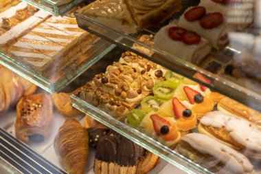 Şekerlemeler ve çeşitli hamur işleriyle dolu bir vitrin. Çok renkliydi. Seçici odak.