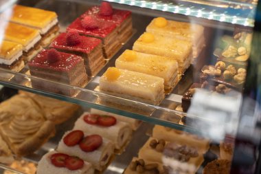 Şekerlemeler ve çeşitli hamur işleriyle dolu bir vitrin. Çok renkliydi. Seçici odak.