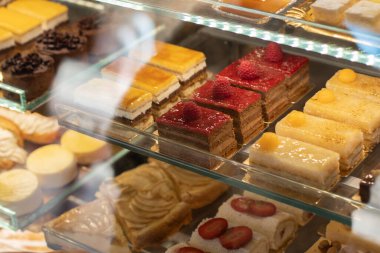 Şekerlemeler ve çeşitli hamur işleriyle dolu bir vitrin. Çok renkliydi. Seçici odak.