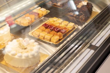 Şekerlemeler ve çeşitli hamur işleriyle dolu bir vitrin. Çok renkliydi. Seçici odak.