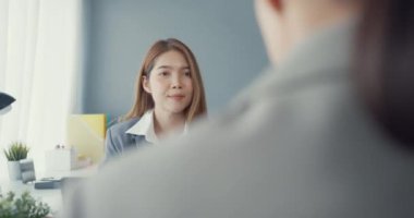 Bir grup Asyalı yaratıcı grup, çalışma masasında çalışırken ve iş yerindeki ofis masasında iletişim kurarken evrak ve dizüstü bilgisayardaki noktaları karşılaştırmak için projeyi tartışıyor. Ortak işbirliği, iş arkadaşı takım çalışması.