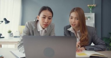 Bir grup Asyalı yaratıcı grup, çalışma masasında çalışırken ve iş yerindeki ofis masasında iletişim kurarken evrak ve dizüstü bilgisayardaki noktaları karşılaştırmak için projeyi tartışıyor. Ortak işbirliği, iş arkadaşı takım çalışması.