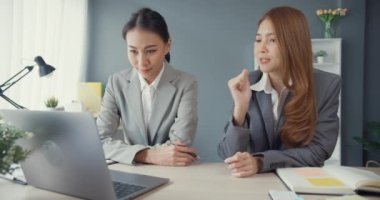 Bir grup Asyalı yaratıcı grup, çalışma masasında çalışırken ve iş yerindeki ofis masasında iletişim kurarken evrak ve dizüstü bilgisayardaki noktaları karşılaştırmak için projeyi tartışıyor. Ortak işbirliği, iş arkadaşı takım çalışması.