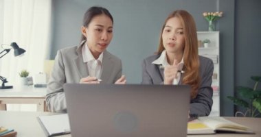 Bir grup Asyalı yaratıcı grup, çalışma masasında çalışırken ve iş yerindeki ofis masasında iletişim kurarken evrak ve dizüstü bilgisayardaki noktaları karşılaştırmak için projeyi tartışıyor. Ortak işbirliği, iş arkadaşı takım çalışması.