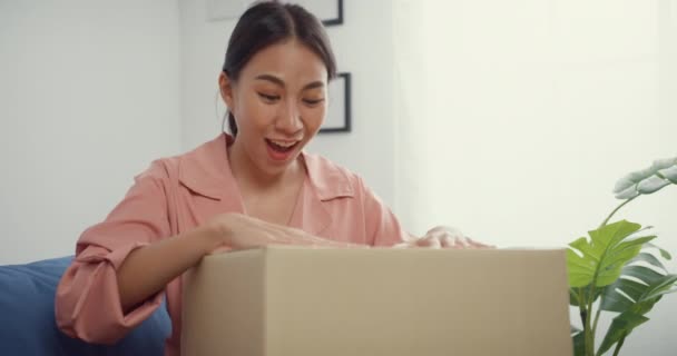 아시아인 아가씨가 온라인 시장에서 거실에서 마분지 패키지입니다 온라인 Unboxing Goods — 비디오