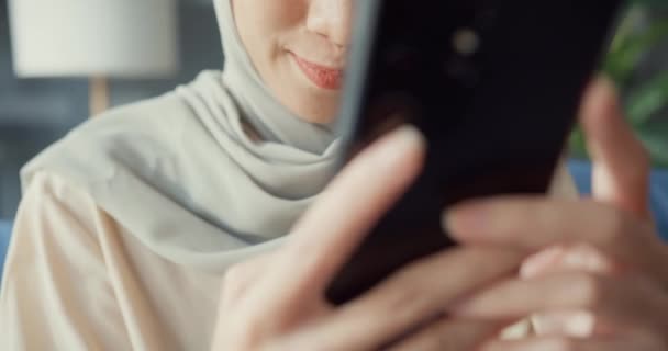 소파에 자세로 거실에서 온라인 쇼핑을 즐기는 히잡에 매력적 아시아 이슬람 — 비디오
