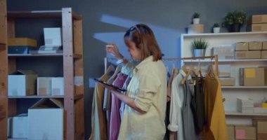 Asyalı genç bir moda tasarımcısı ve sıradan bir tableti var. Envanter kontrol ürünleri teslimat ürünlerini gece vakti kumaş dükkanındaki sipariş standına teslim ediyor. Küçük işletme kavramı.