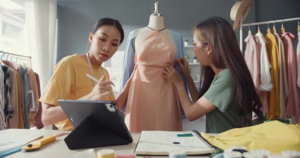 两名年轻的亚洲女士裁缝师在商店里用针头为模特们设计了一套新的服装收藏共享理念 协作概念 裁缝行业概念 — 图库视频影像