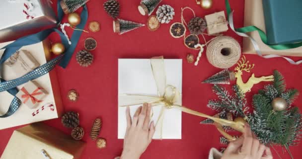 크리스마스 상자의 포장을 사진붉은 배경으로 크리스마스 장식을 소수의 창의적 크리스마스 — 비디오