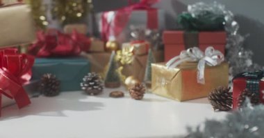 Kızların ellerini kapayın ve hediye kutusunu hazırlayın. Kış Noel süslerini masaya koyun. Geleneksel Noel kompozisyonu ve yeni yıl tatili sezonunun en az yaratıcılığı.