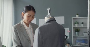 Başarılı bir moda tasarımcısı. Çekici Asya 'lı genç ve zeki iş kadını kollarını çapraz tutuyor ve stüdyo atölyesinde güzel bir gülümseme standı olan kameraya bakıyor. Küçük işletme başlangıç konsepti.