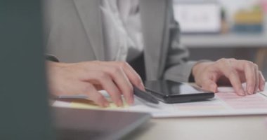 Yakın plan genç Asya 'lı profesyonel kadın dizüstü bilgisayarı ve akıllı telefonuyla ofiste evrak işleri ile ilgili pazarlama araştırma çizelgesini analiz ediyor. Kadın iş elbisesi, teknoloji girişimi iş konsepti.