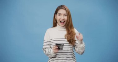 Süveteri olan genç ve çekici Asya 'lı bayan telefonu kullan. Fotokopi odası reklamı, sosyal medya, gazeteciler mavi arka planda izole edilmiş. Kadın gülüşü Vay be, dükkan bağlanıyor ve sörf yapılıyor.
